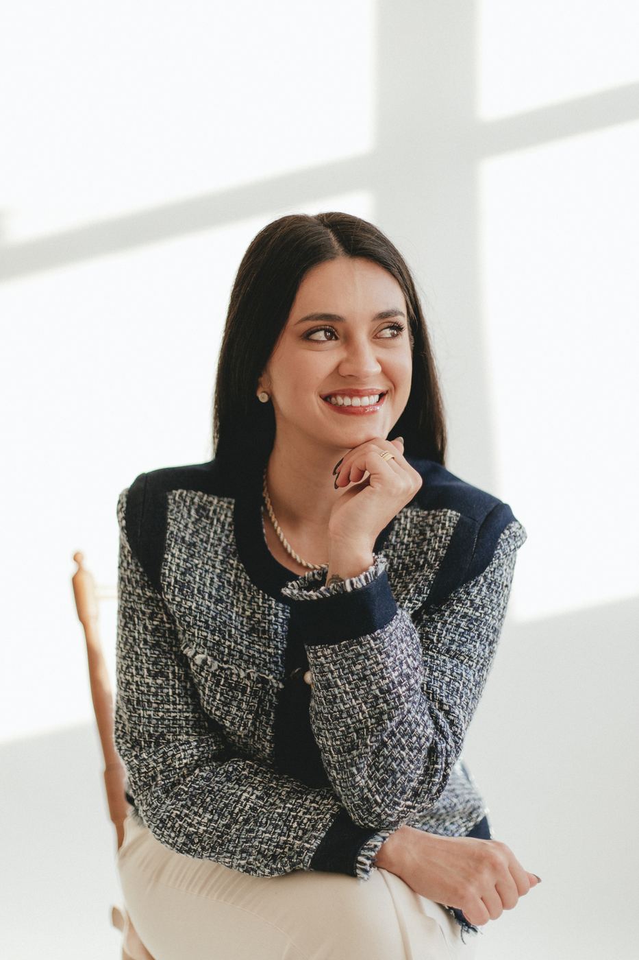 Dra. Mariana Motta sorrindo, de blazer de tweed azul